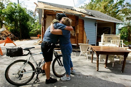 Seabrook, TX police officer Jeff Galyean hugs his 4th grade teacher, Sue Harral, on Tuesday in front of her home.  The house was swept into the middle of the street and was several hundred feet from its foundation.  Mark Wilson / Getty Images