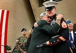 Dallas City Hall, Veterans Day, November 11, 2004. Houston James, a survivor of the attack on Pearl Harbor, hugs Marine Staff Sergeant Mark Graunke Jr., a member of an explosive disposal team who lost his left hand, one leg and an eye in Iraq.  